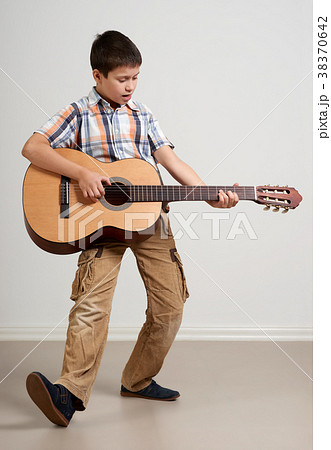 Boy is playing the acoustic guitar Boy is playing the acoustic guitar 38370642