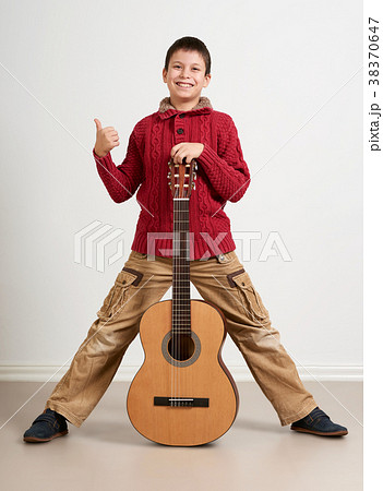 Boy is playing the acoustic guitar 38370647