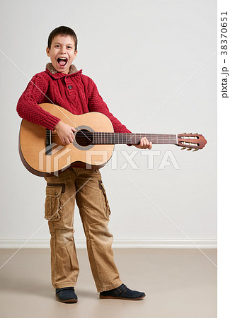 Boy is playing the acoustic guitar Boy is playing the acoustic guitar 38370651