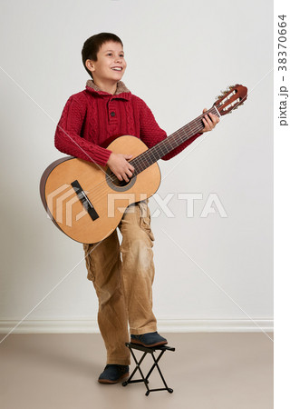 Boy is playing the acoustic guitar 38370664
