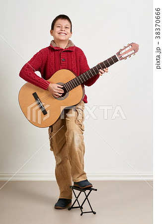 Boy is playing the acoustic guitar Boy is playing the acoustic guitar 38370666