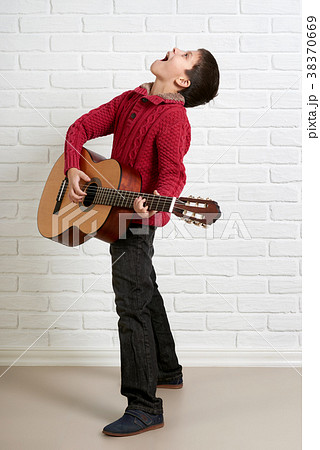 Boy is playing the acoustic guitar Boy is playing the acoustic guitar 38370669