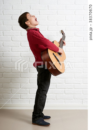 Boy is playing the acoustic guitar 38370670