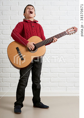 Boy is playing the acoustic guitar 38370671