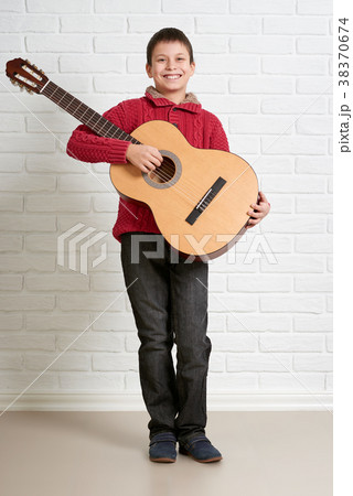 Boy is playing the acoustic guitar 38370674
