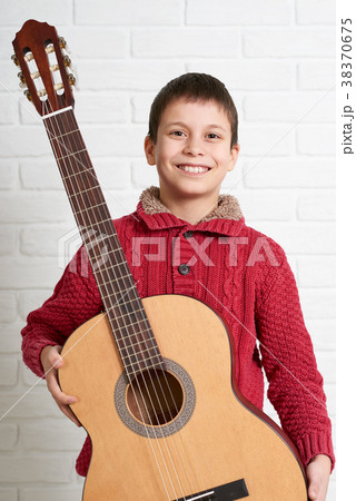Boy is playing the acoustic guitar 38370675