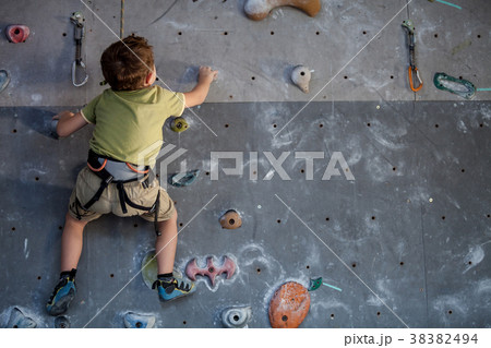 little boy climbing a rock wall indoor. little boy climbing a rock wall indoor. 38382494