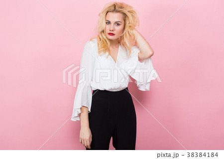 Blonde woman in white blouse and black pants 38384184