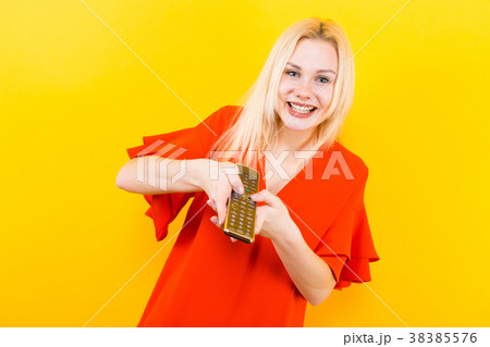 Blonde woman in dress with remote control Blonde woman in dress with remote control 38385576