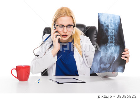 Woman doctor in white coat carefully studies X-ray 38385825