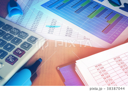Calculator and financial figures on office table. Calculator and financial figures on office table. 38387044