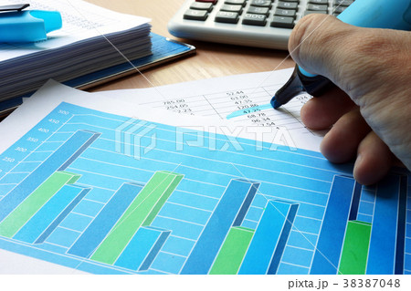 Auditor is underlined financial data in a report. Auditor is underlined financial data in a report. 38387048