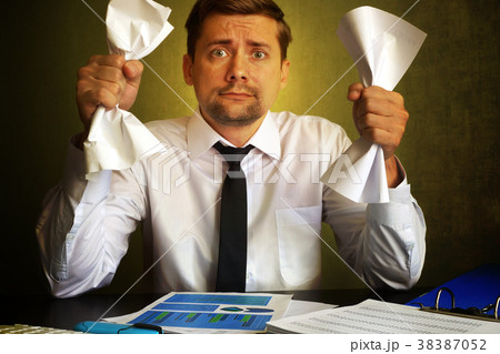 Nervous businessman observing bills.   38387052