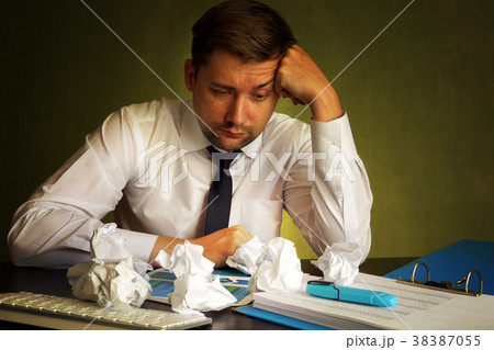 Frustrated businessman looking on financial report 38387055