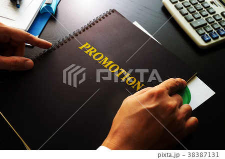 Man holding book with title promotion. Man holding book with title promotion. 38387131