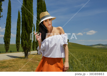 Woman is walking along the road among the fields and a typical T 38389863