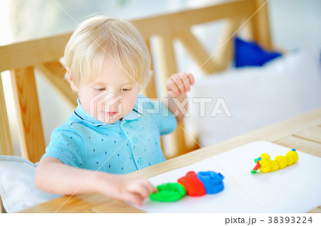 Creative boy playing with colorful modeling clay  38393224