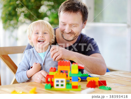 boy with his father playing with plastic blocks boy with his father playing with plastic blocks 38393418