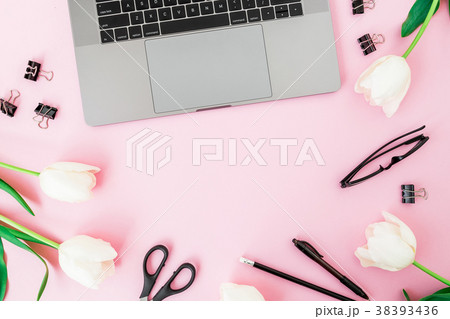 Office desk with laptop, white tulips, glasses 38393436