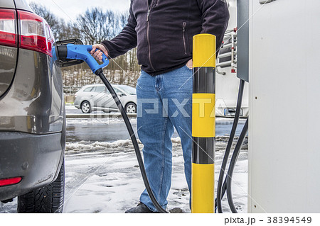 Man charging his electric car Man charging his electric car 38394549