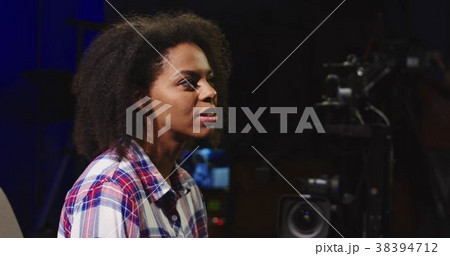 Casual black woman hosting TV show 38394712