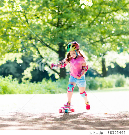 Child riding skateboard in summer park 38395445