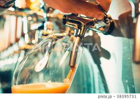 Hand of bartender pouring a large lager beer in Hand of bartender pouring a large lager beer in 38395731