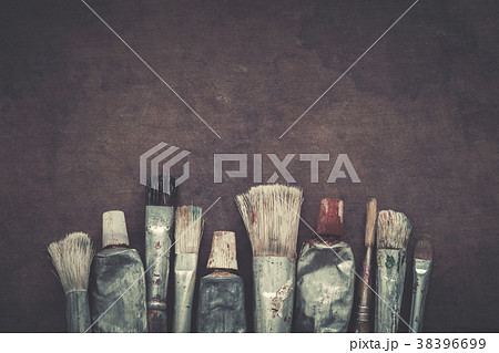 Paintbrushes, paint tubes closeup on dark canvas. 38396699