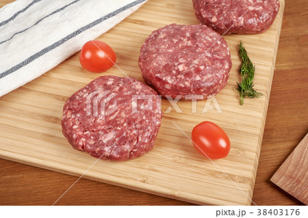 Raw cutlet of minced meat on a wooden cutting 38403176