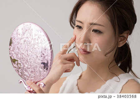 肌を気にする若い日本人女性の写真素材 肌を気にする若い日本人女性の写真素材