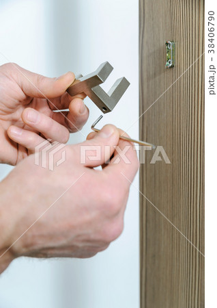 A man is installing a hook. 38406790