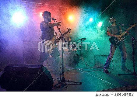 Rock band performs on stage. Guitarist, bass guitar and drums. Rock band performs on stage. Guitarist, bass guitar and drums. 38408485