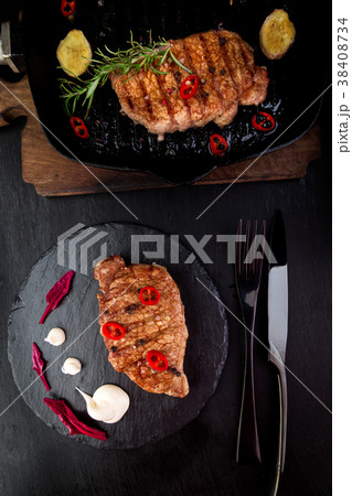 Grilled pork steak on slate plate. 38408734