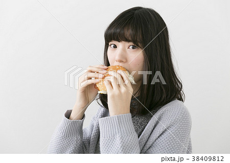 ハンバーガーを食べる女性の写真素材