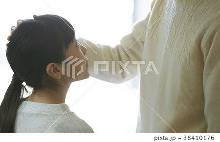 娘の頭を撫でる父親の写真素材