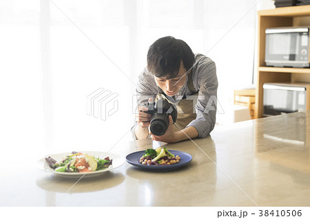 料理を撮影する男性 38410506