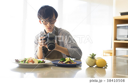 料理を撮影する男性 38410508