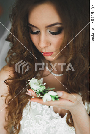 Gorgeous bride in robe posing and preparing for 38419257