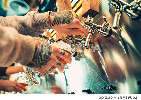 Hand of bartender pouring a large lager beer in Hand of bartender pouring a large lager beer in 38419662
