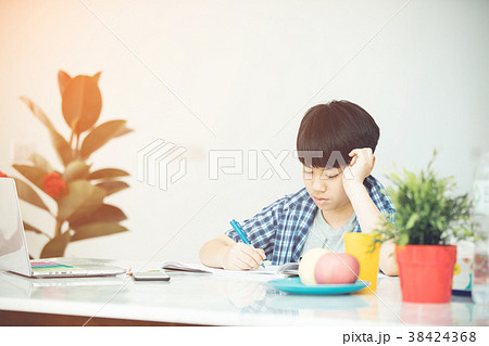 Cute little boy reading book with serious face . 38424368