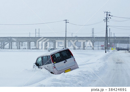 雪道の事故 道路を逸脱した軽自動車の写真素材