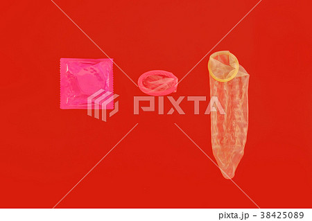 Male condom on red background 38425089