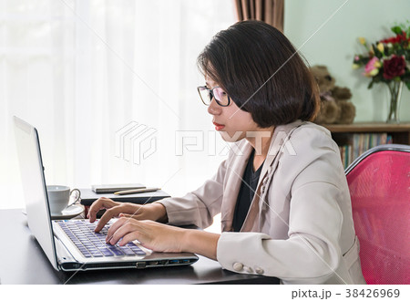 Young woman in smart casual wear working on laptop 38426969