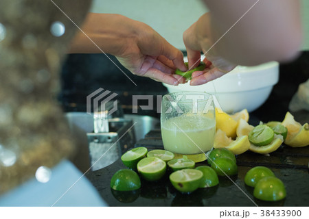 Asian lady hands squeeze green lime juice  38433900