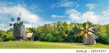 Old wooden windmill in a field and sky. Wide photo Old wooden windmill in a field and sky. Wide photo 38434347
