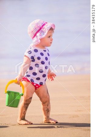 Little girl playing on the beach 38435179