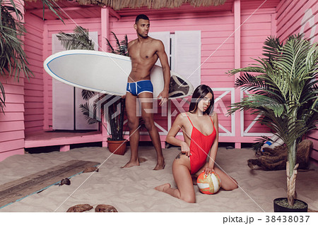Sexy man and woman on the beach near a bungalow. 38438037