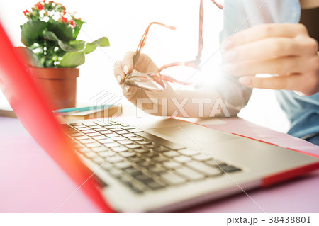 Woman working on computer in office and holding Woman working on computer in office and holding 38438801
