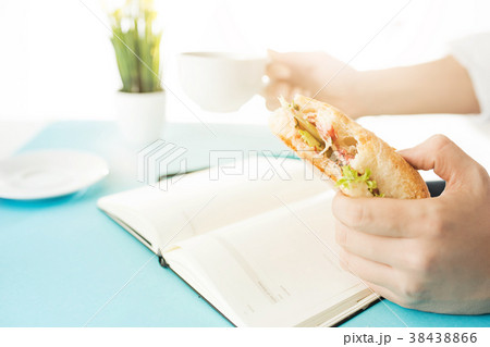 The male hands holding pen and sandwich. The The male hands holding pen and sandwich. The 38438866