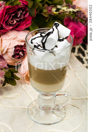 Tall glass with latte and marshmallow on wooden Tall glass with latte and marshmallow on wooden 38440302